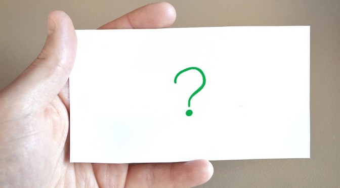 hand holding paper with question mark on it