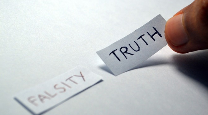 pieces of paper with 'falsity and truth' written on them